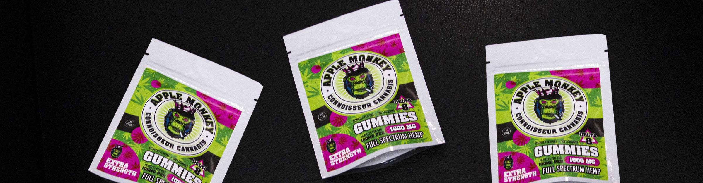 Wholesale Apple Monkey Delta 8 gummies on black background in florescent lighting