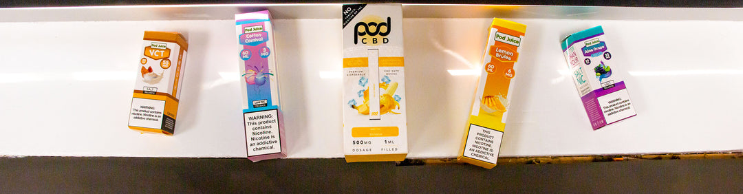 Wholesale Pod Juice various flavors laying down on white counter top