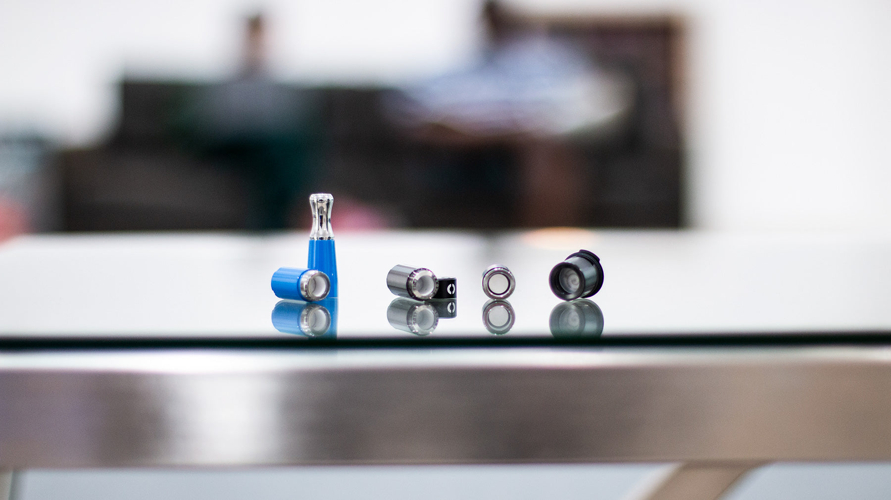 Wholesale Vape Tanks laying down in a row on a glass table inside office building lobby